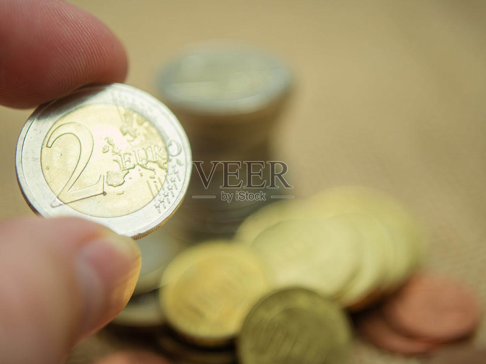 手持两枚欧元硬币特写照片摄影图片