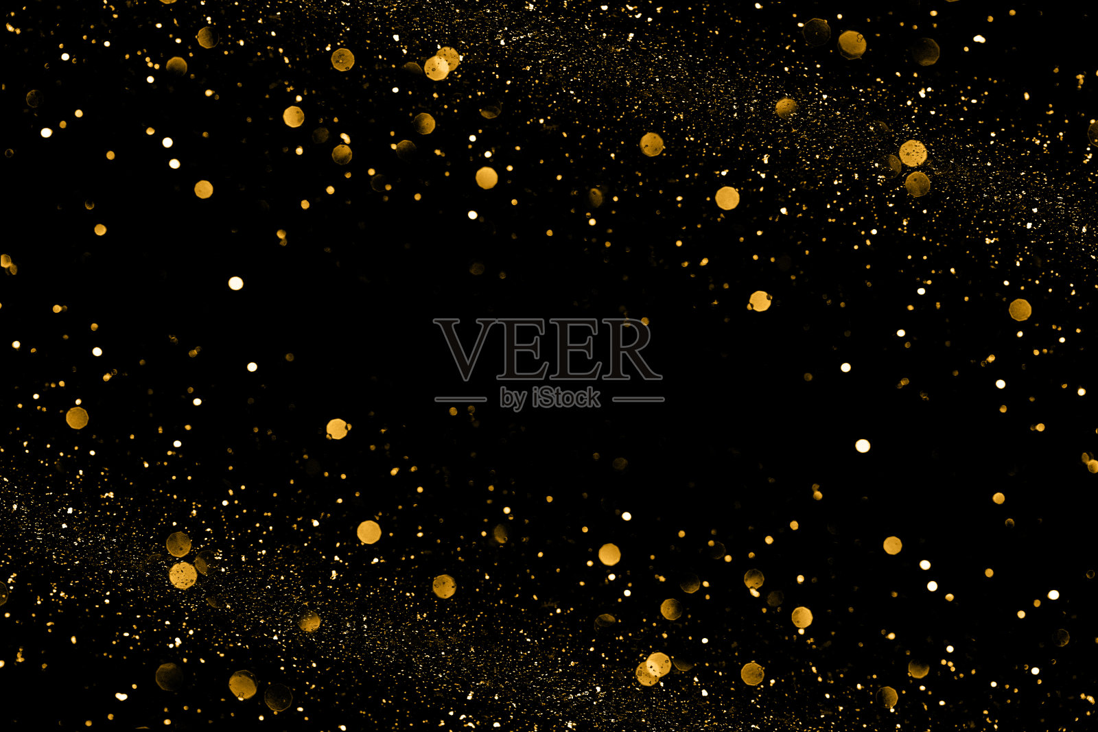 金色散景和闪亮的粒子在黑色背景神奇的设计。照片摄影图片