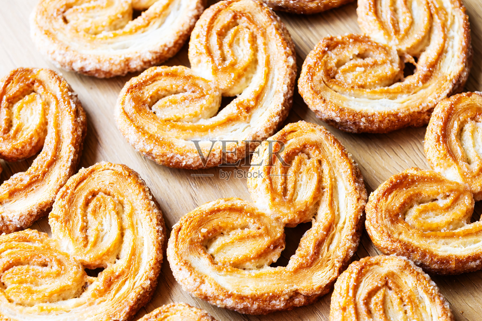 木制背景上的心形自制酥皮糕点。照片摄影图片