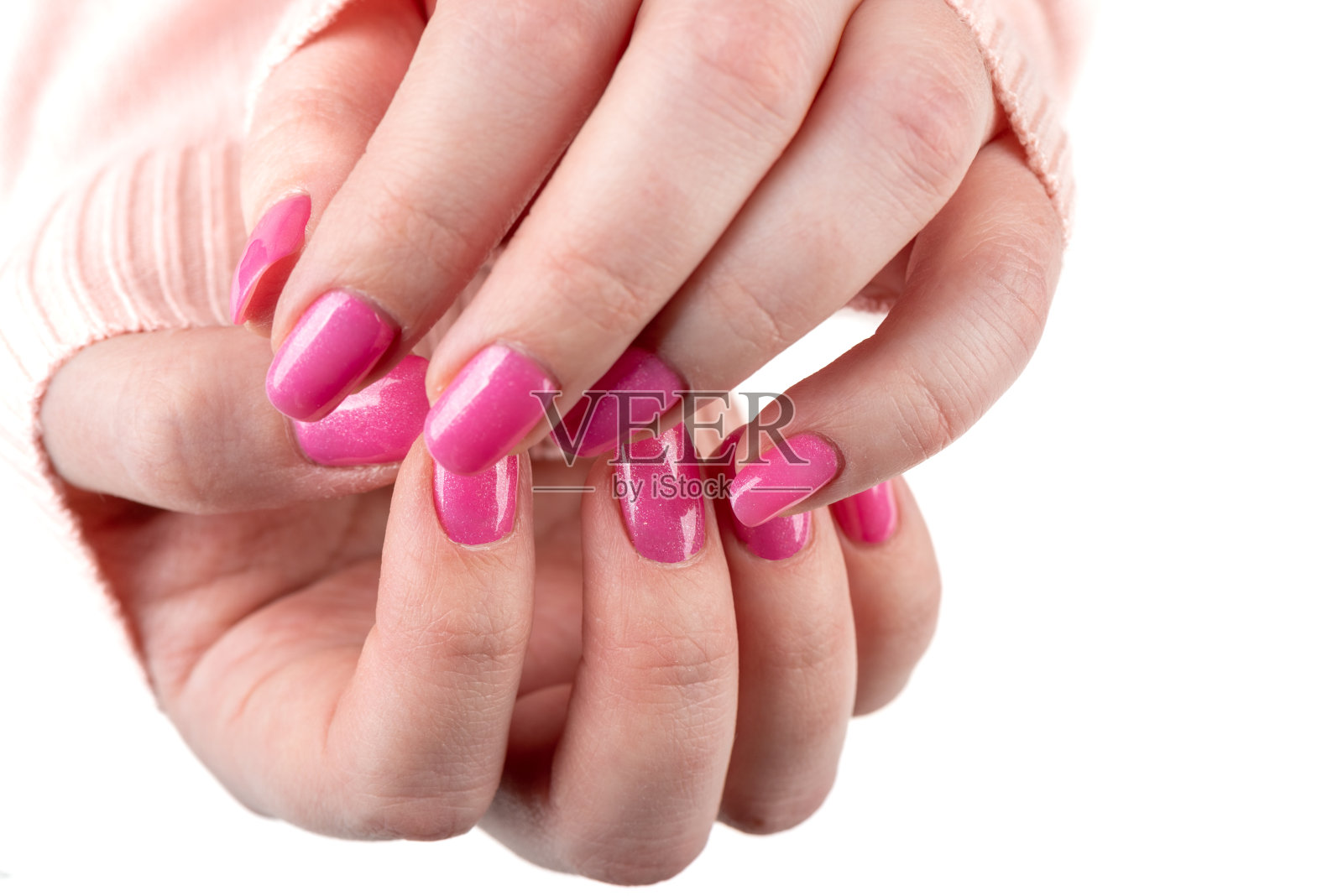 女孩手指上时髦的粉色指甲。照片摄影图片