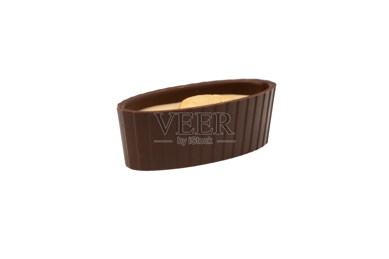 白色背景上有一颗坚果的巧克力糖。照片摄影图片