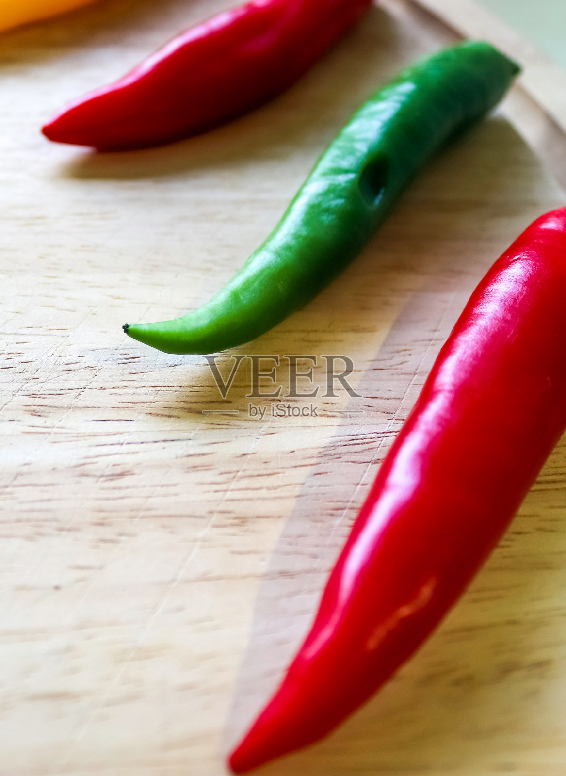 顶部和视角的辣椒和钢刀在木制砧板与孤立的背景照片摄影图片