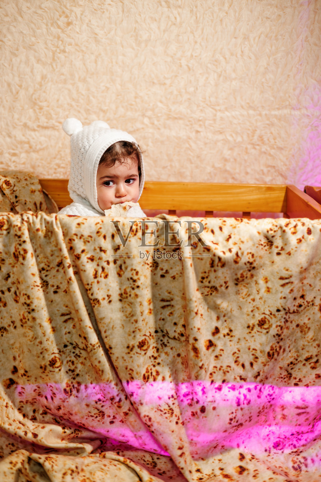 昏昏欲睡的零食时间。可爱的孩子在睡觉前在婴儿床上享用面包照片摄影图片