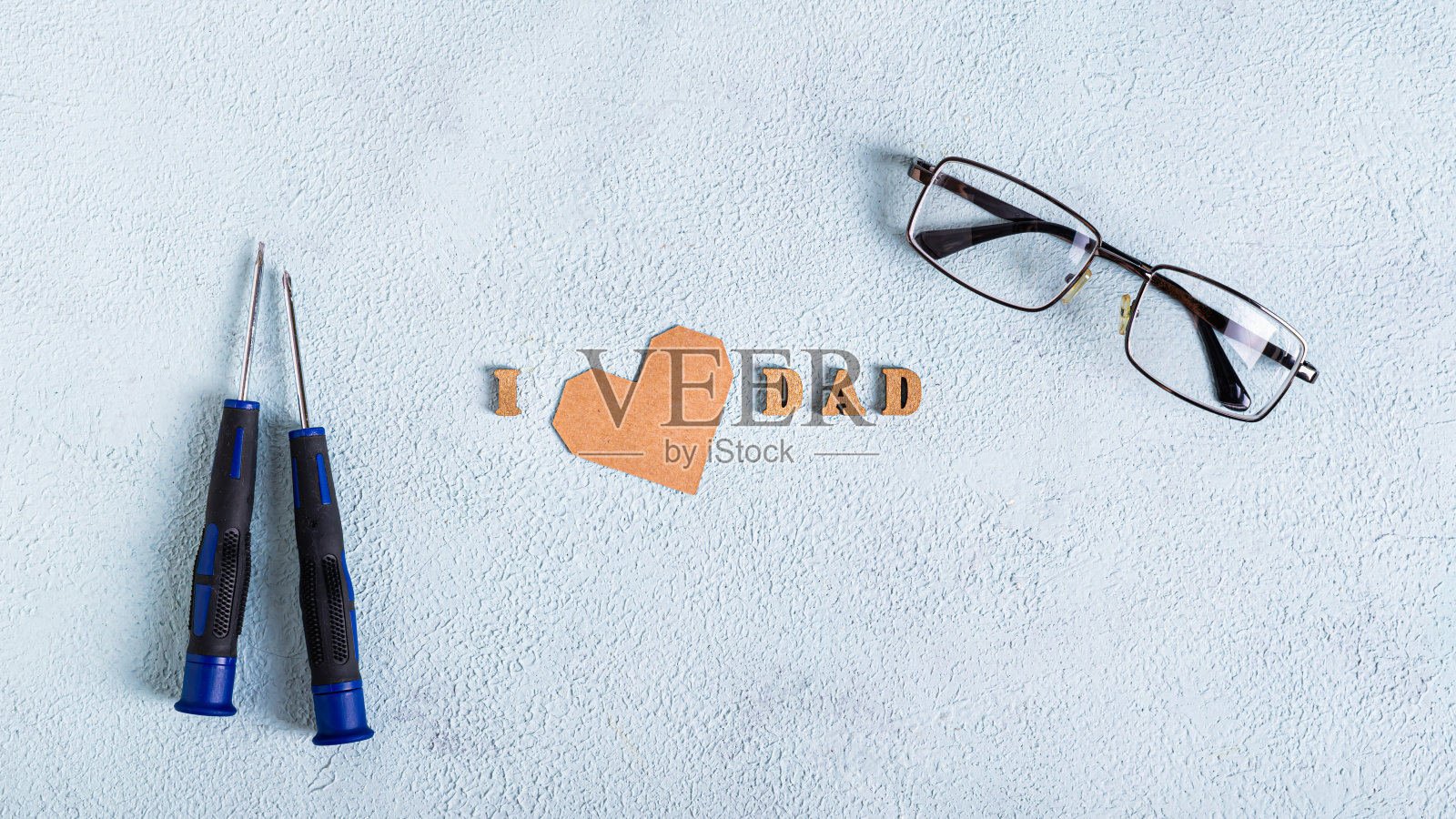 父亲节的眼镜，螺丝刀，蓝底心形和题词照片摄影图片