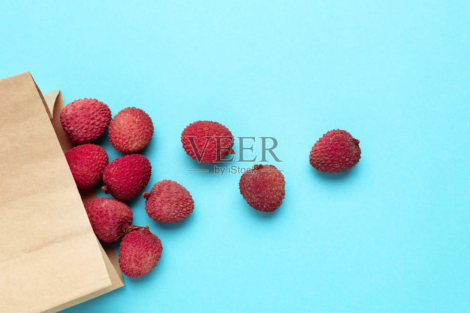 美味的荔枝在蓝色背景纸袋照片摄影图片