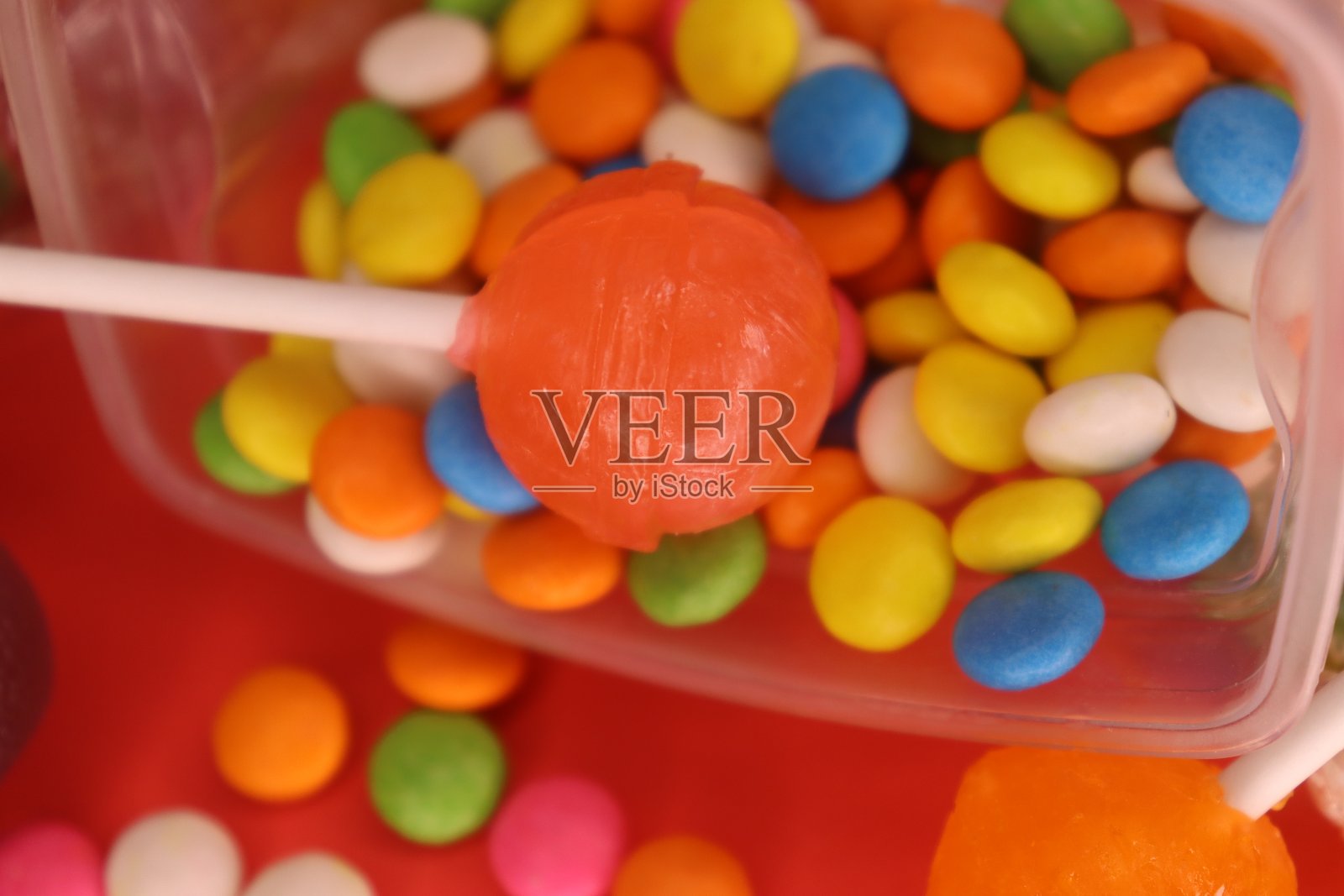 盒子里的圆形棒棒糖，上面有五颜六色的小宝石照片摄影图片