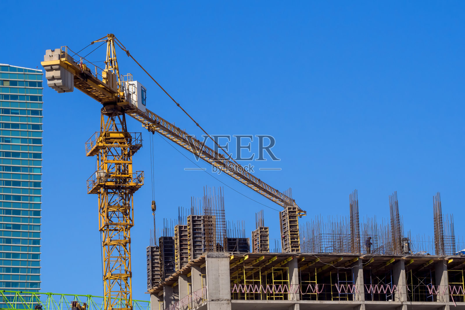 工地上的黄塔吊以蓝天为背景，说明建设、城市的发展与进步照片摄影图片
