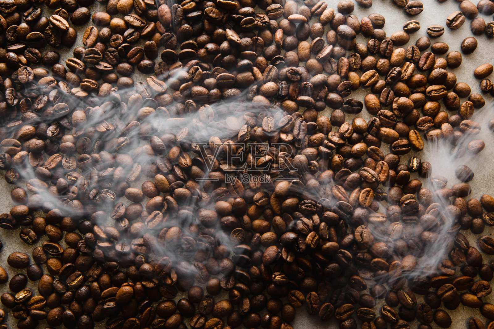 热气腾腾的烘焙咖啡豆从上方捕捉，显示出新鲜和香气照片摄影图片