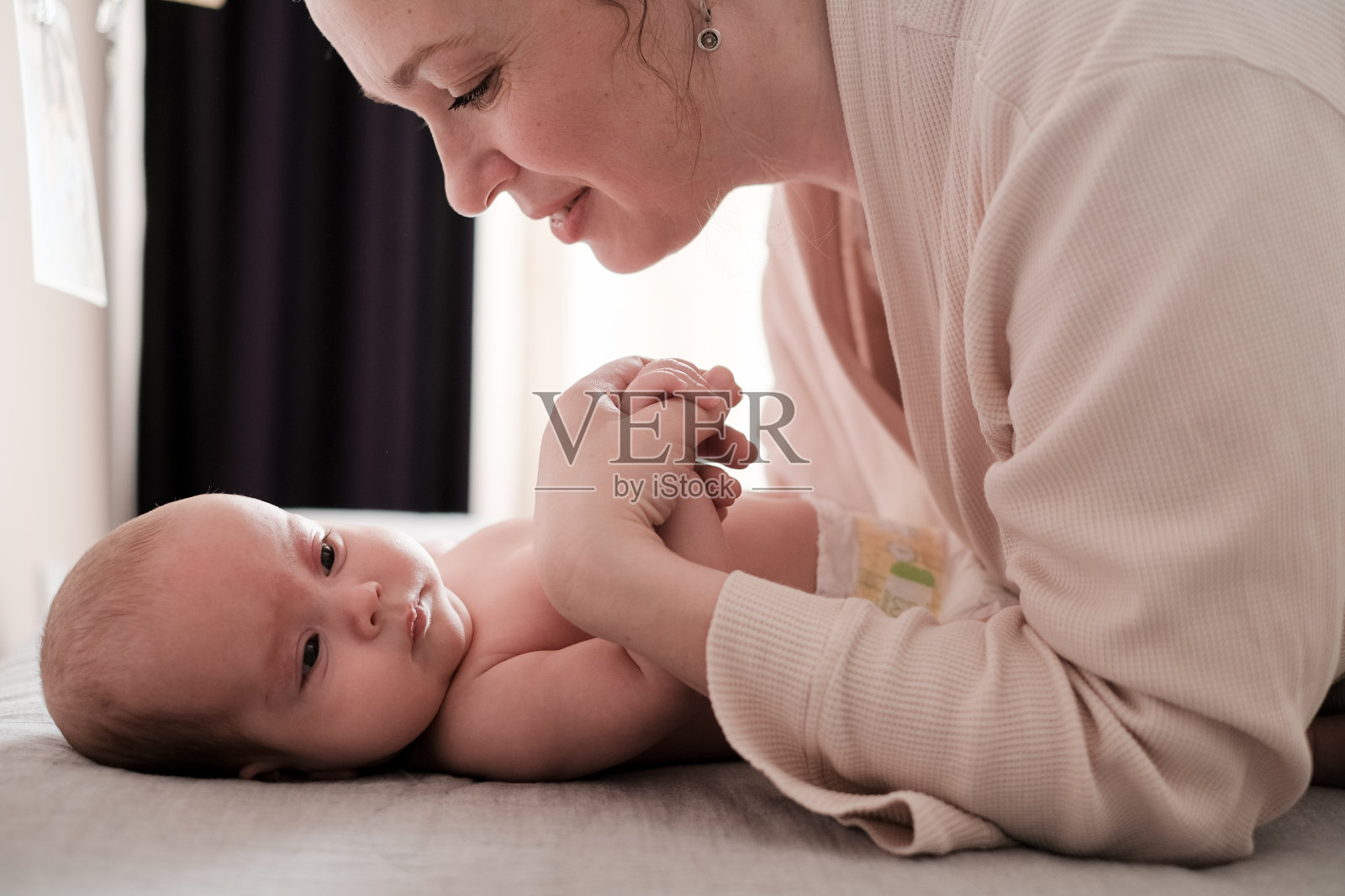 母亲和她刚出生的婴儿玩耍。为人父母，童年，母亲照片摄影图片