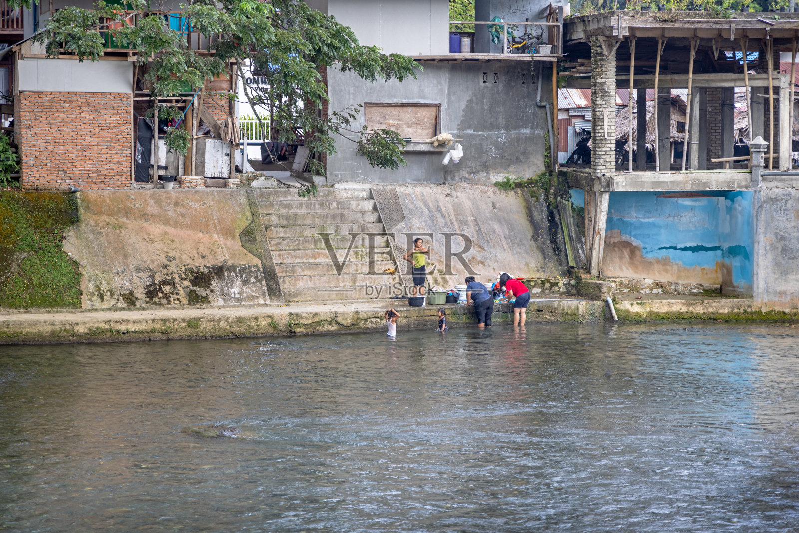 人们在河里既洗衣服又洗自己照片摄影图片