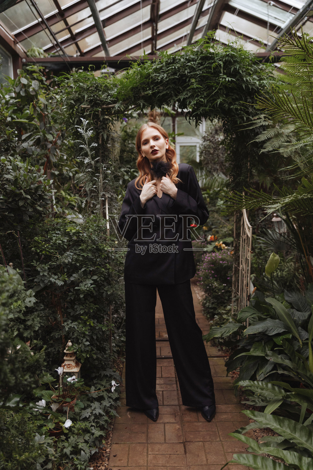一个女人穿过温室。照片摄影图片