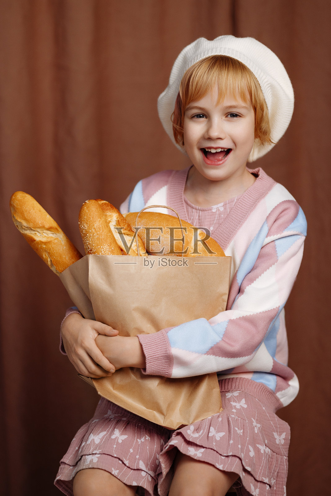 女孩拿着装满面包的袋子。照片摄影图片