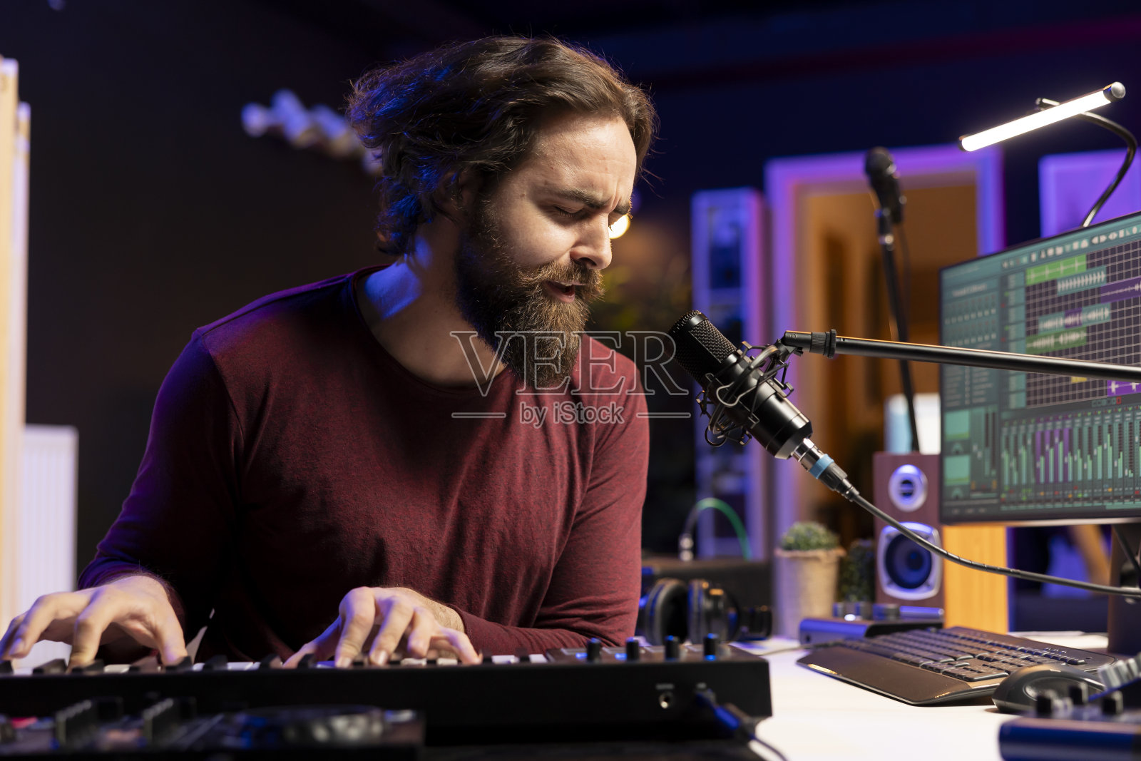 音乐制作人演奏电子钢琴键盘音符和麦克风唱歌照片摄影图片