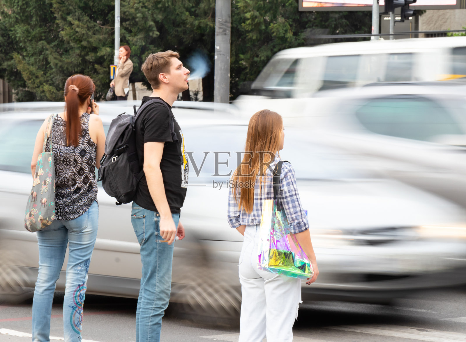 行人站在人行道上，等待穿过繁忙的十字路口照片摄影图片