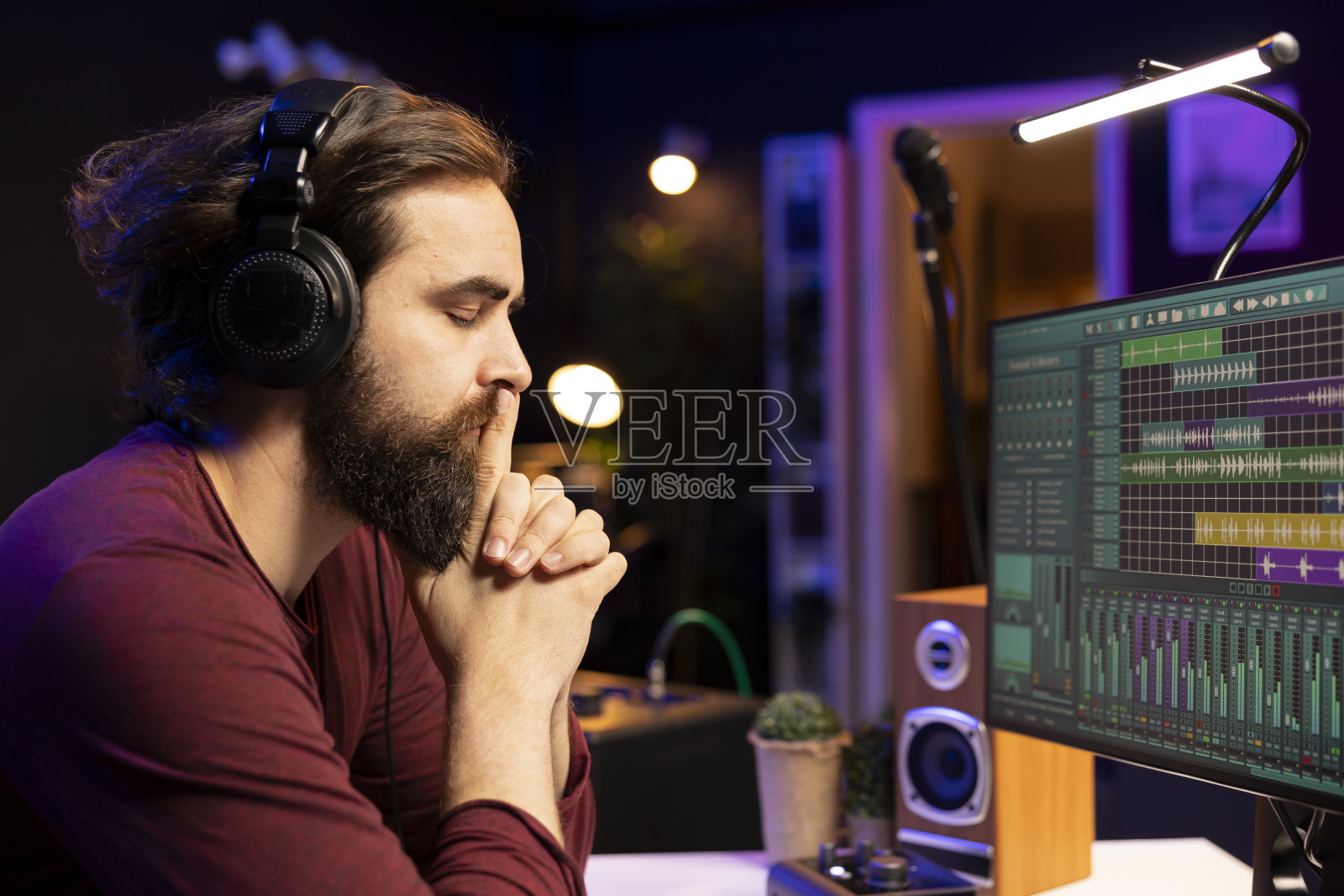 音乐制作人正在仔细听他剪辑后的录音照片摄影图片