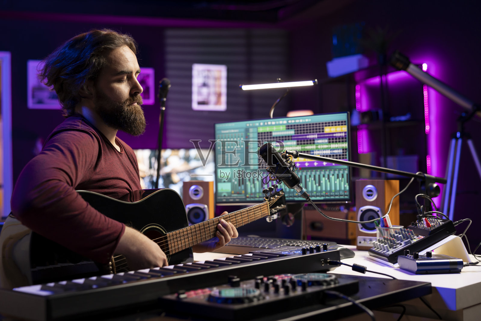 有创造力的音乐家在麦克风上唱着旋律，弹着吉他照片摄影图片