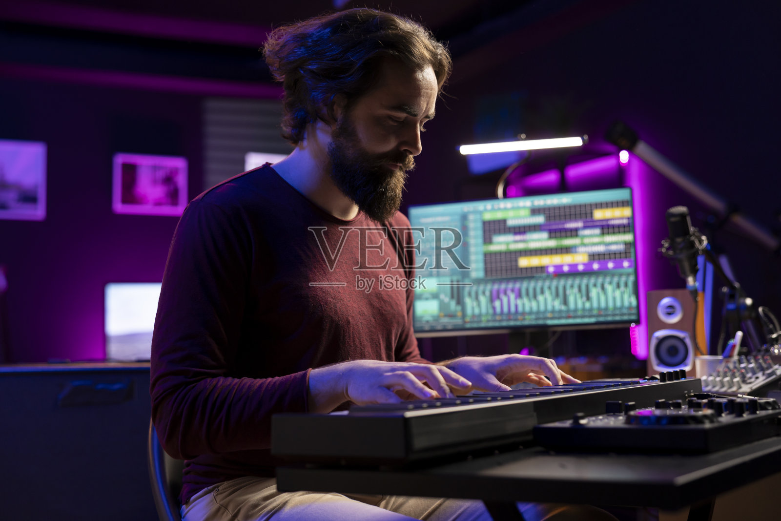 熟练的艺术家创造新的音乐在电子midi控制器在家庭工作室照片摄影图片