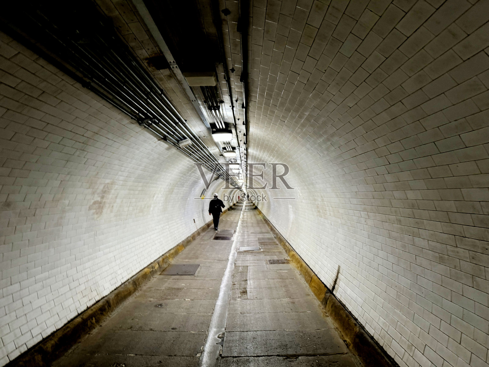 一个人走在隧道里照片摄影图片