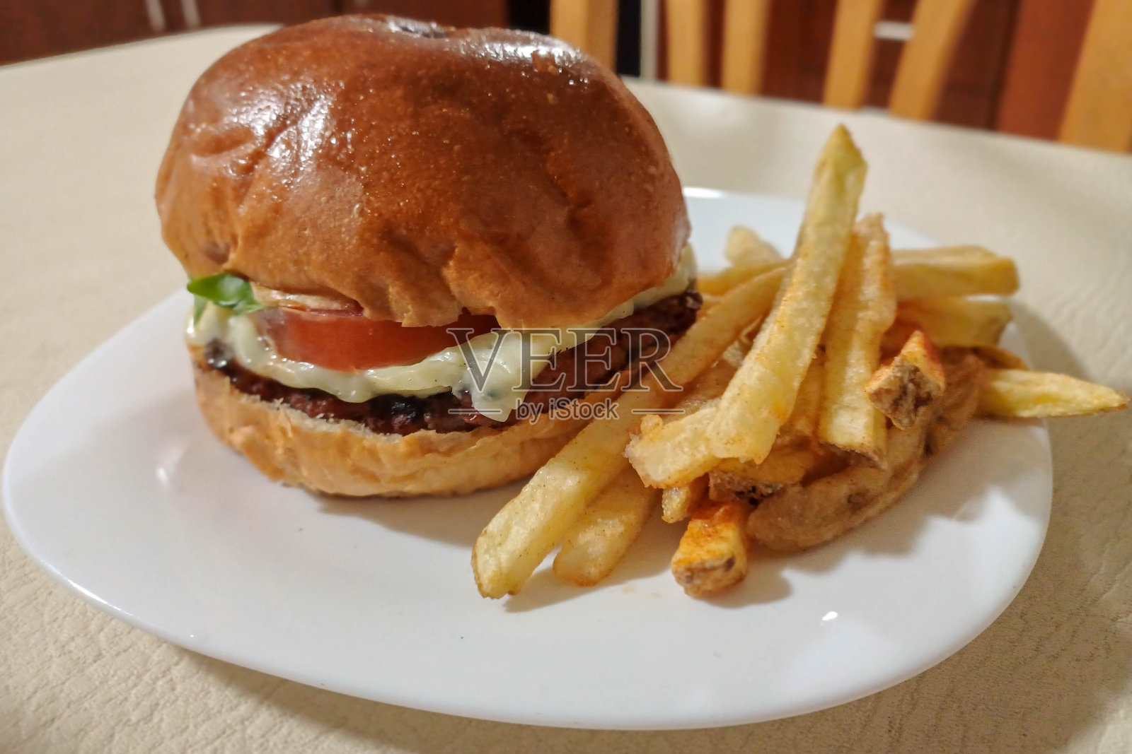 汉堡包和薯条放在桌子上的盘子里照片摄影图片