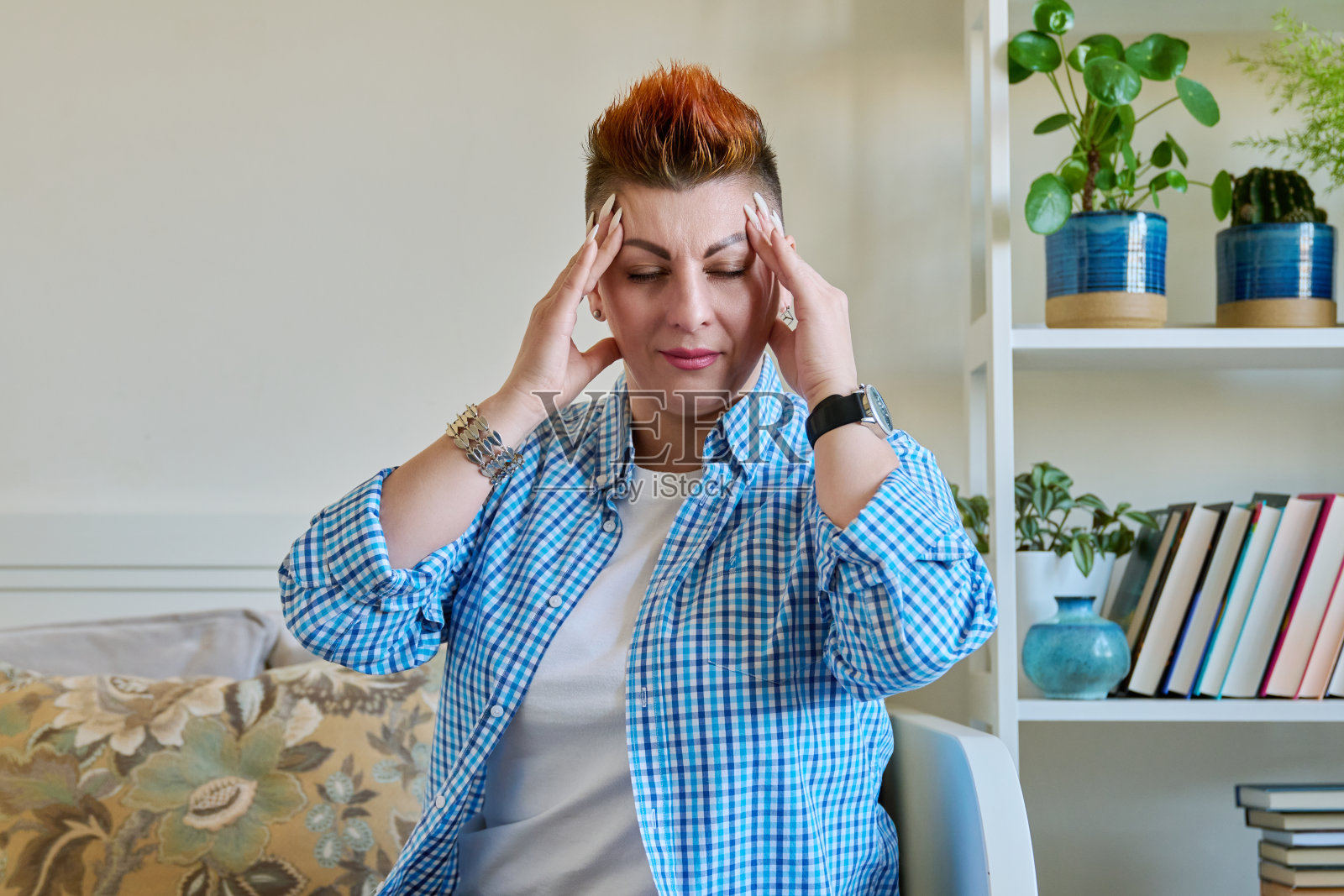 悲伤的中年妇女手扶太阳穴，有健康问题照片摄影图片