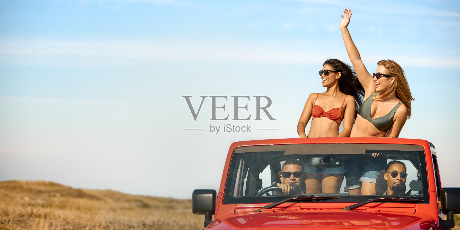 一对夫妇和朋友在度假驾驶汽车在公路旅行冒险到海滩与妇女站立照片摄影图片