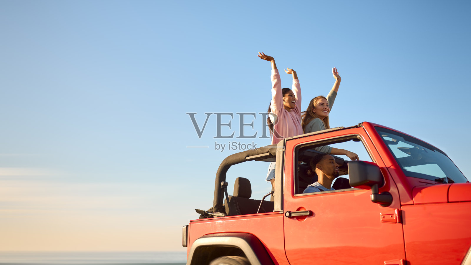 一对夫妇和朋友一起度假，开车去海滩冒险，站在屋顶上照片摄影图片