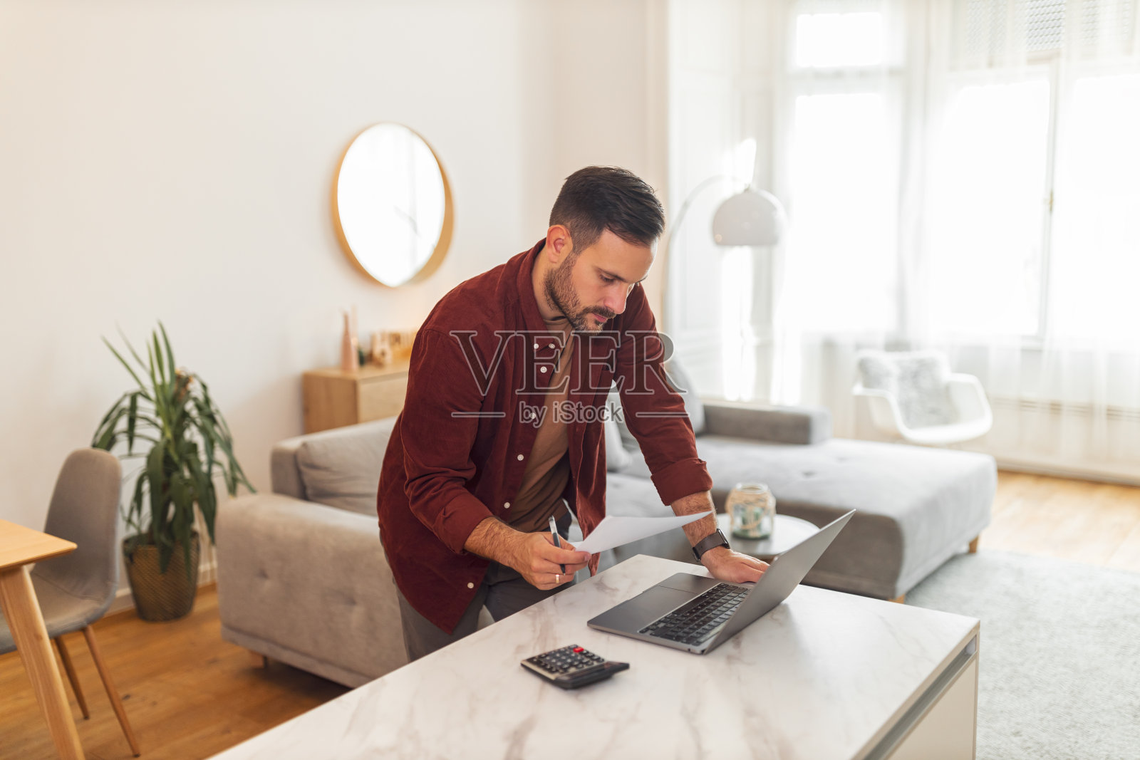 一个专注的年轻成年男性企业家在家工作时检查他的企业财务状况照片摄影图片