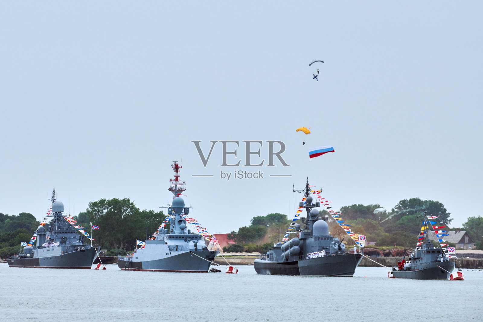 悬挂俄罗斯国旗的空降部队伞兵在海军部队沿着海岸线游行的军舰上照片摄影图片