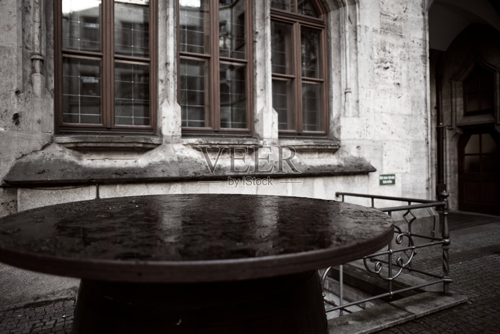 复古的欧洲街道，前景是一张古老的圆桌，背景是历史建筑的窗户。照片摄影图片