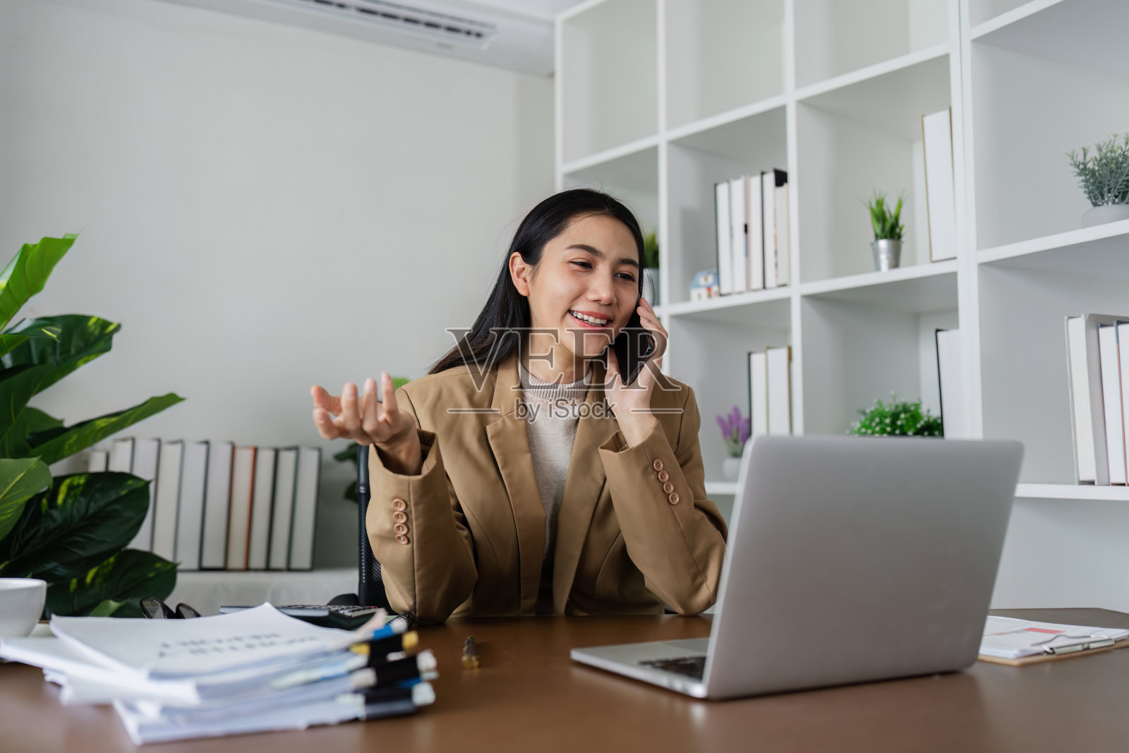 商务女性通过手机与客户、商务合作伙伴进行商务会谈照片摄影图片