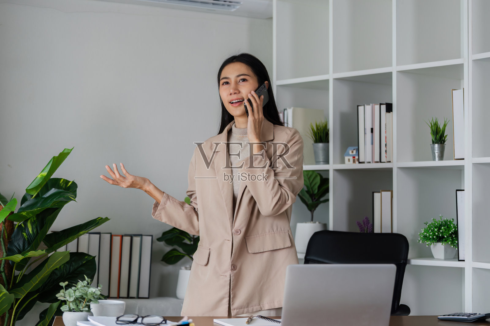 商务女性通过手机与客户、商务合作伙伴进行商务会谈照片摄影图片