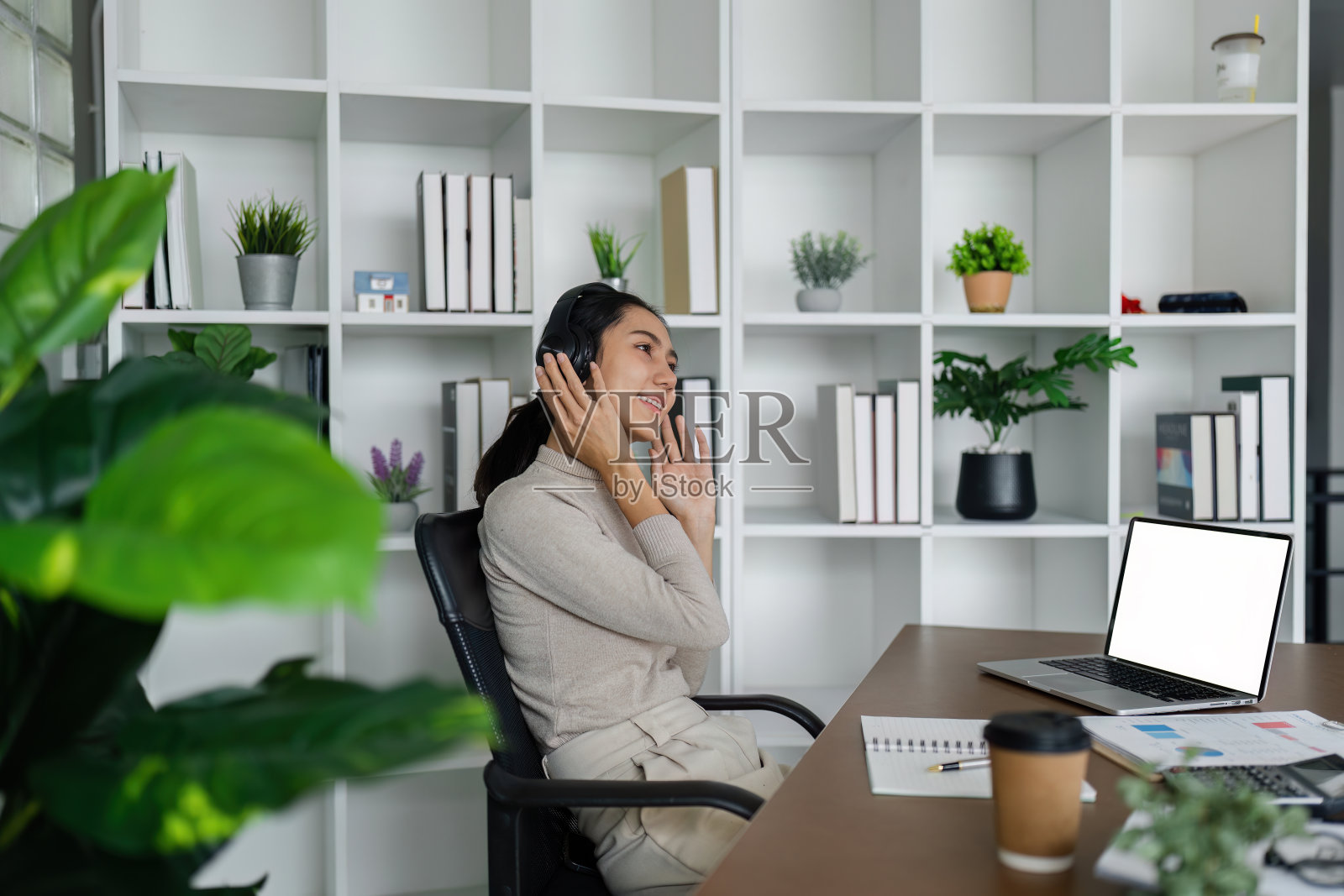 在家使用耳机工作的商务女性，在线会议，远程工作，工作时放松，听音乐照片摄影图片