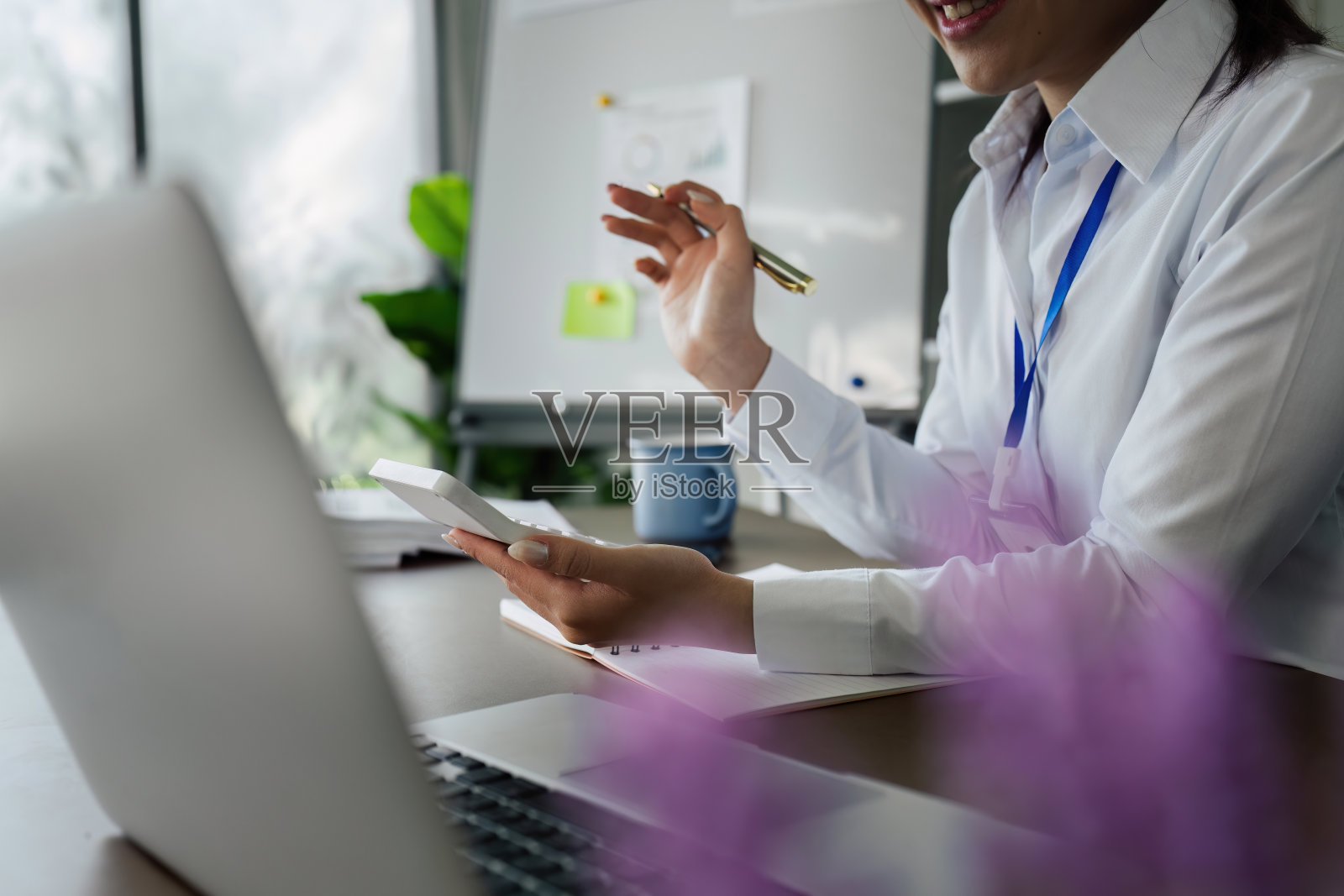 商务财务概念，商务女性在办公室使用计算器计算业务数据照片摄影图片