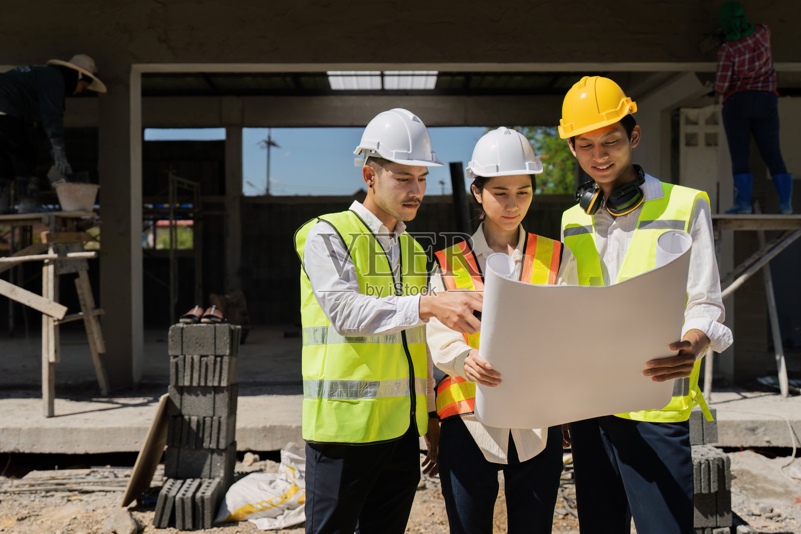 团队工程师，领班，建筑师在现场与同事讨论并检查施工图纸照片摄影图片