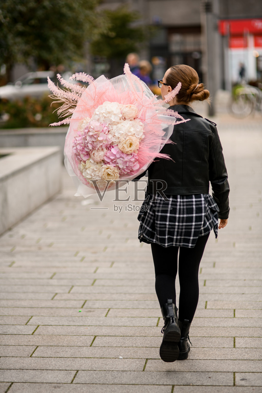 一个年轻苗条的女人，肩上拿着一大束白色和粉红色的绣球花和牡丹照片摄影图片