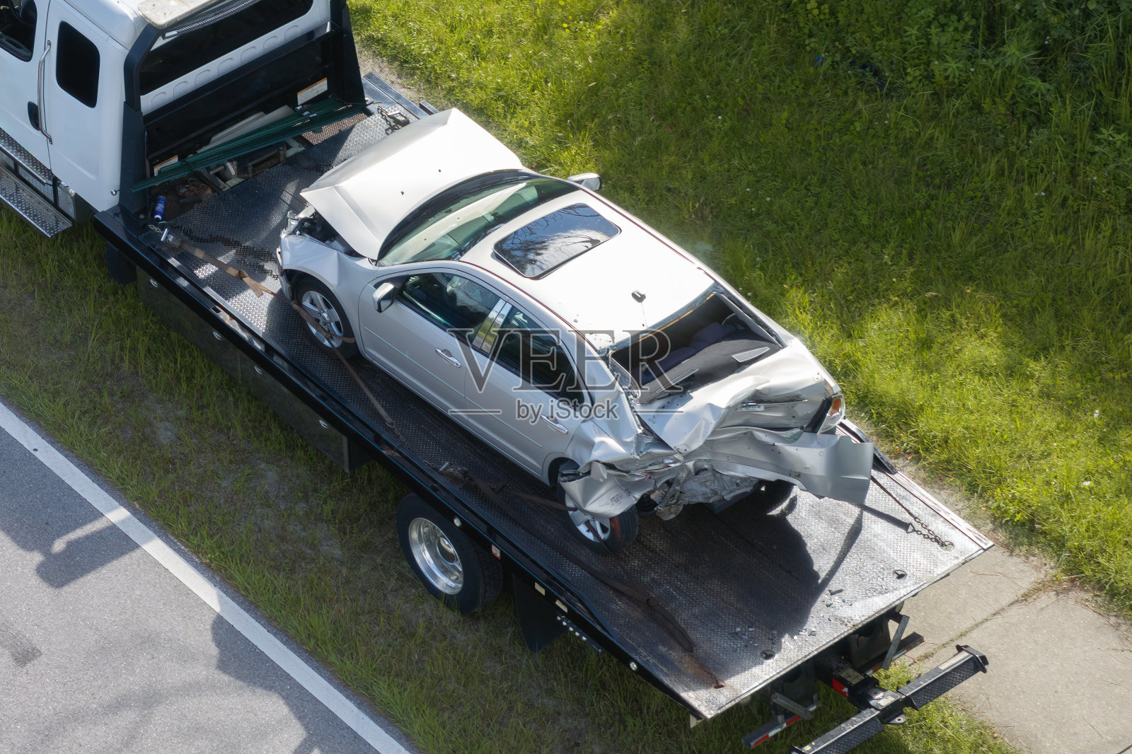 拖车在车祸现场拖拽被撞坏的车辆。紧急服务人员应对美国街道上的交通事故。急救人员在美国的道路上提供帮助照片摄影图片
