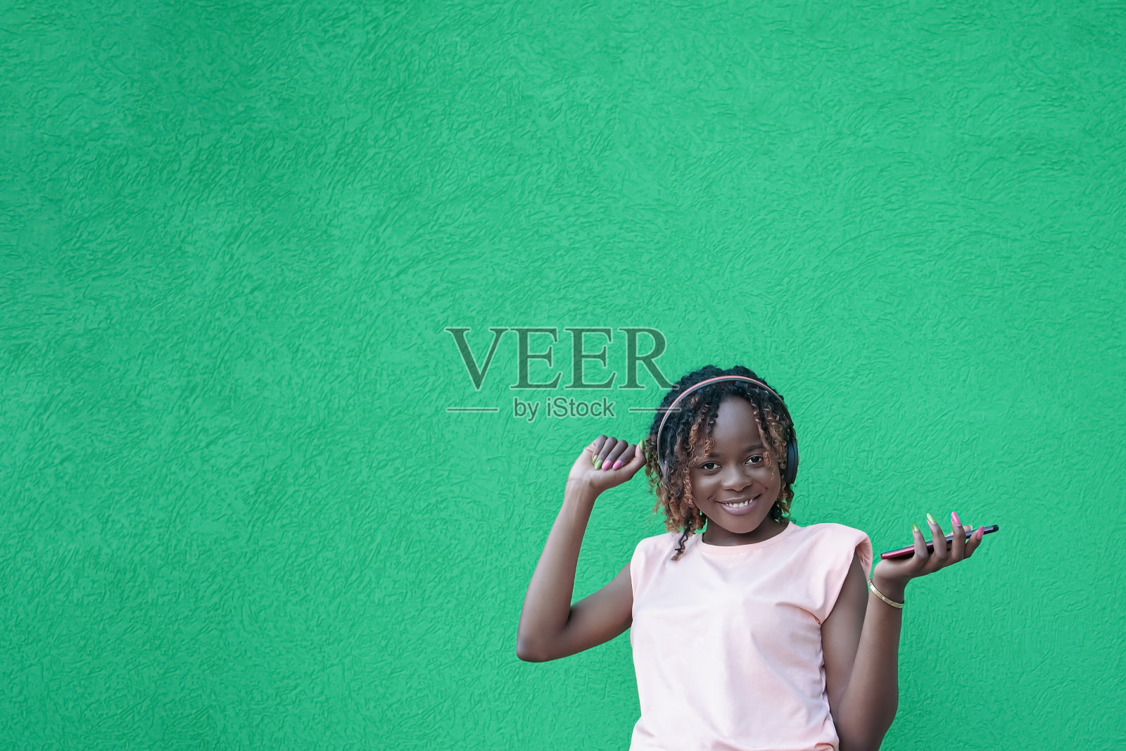 一位戴着耳机微笑的女士正在听音乐。无线技术。本空间照片摄影图片