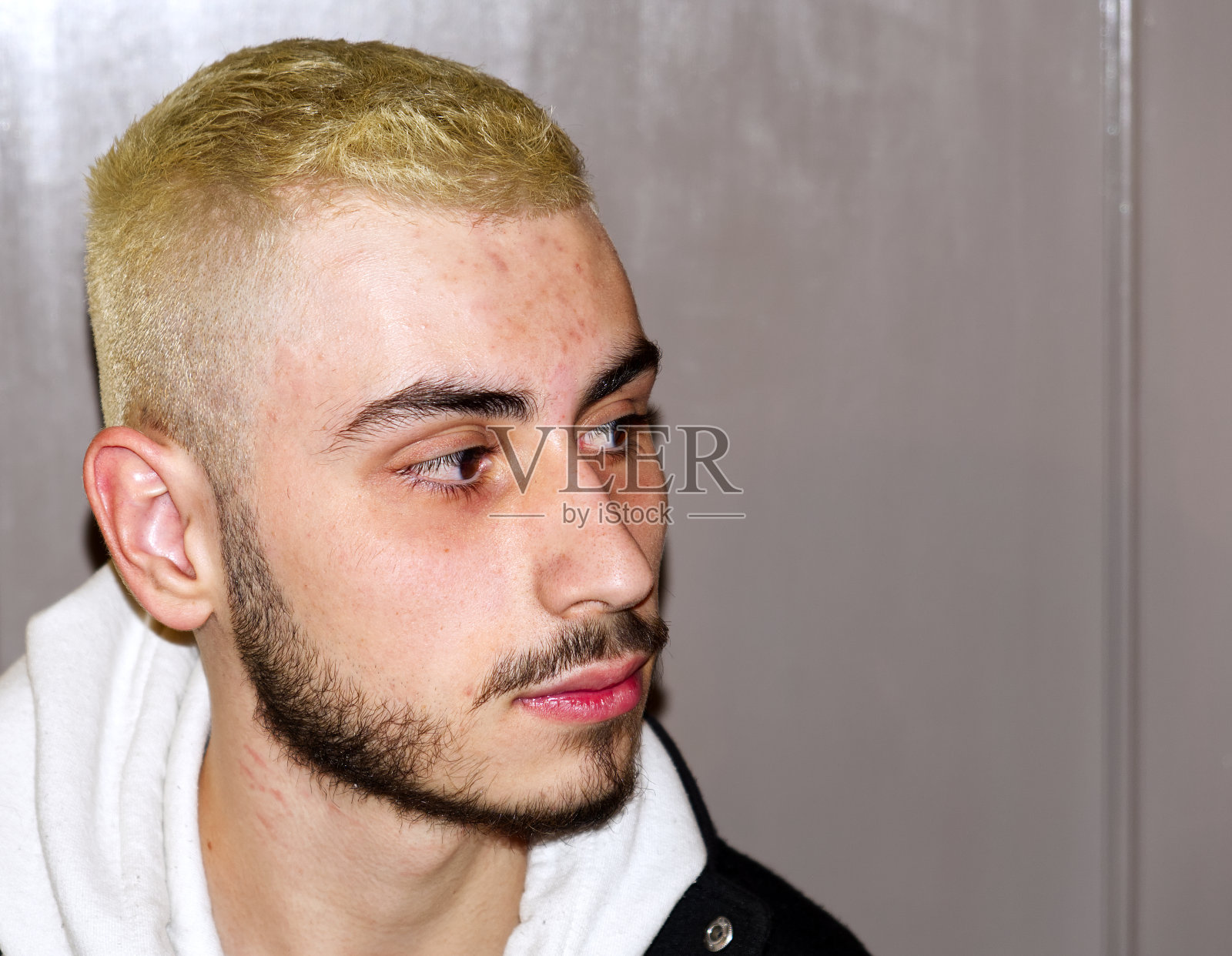 白种人男孩的特写，留着胡子，头发漂白了照片摄影图片