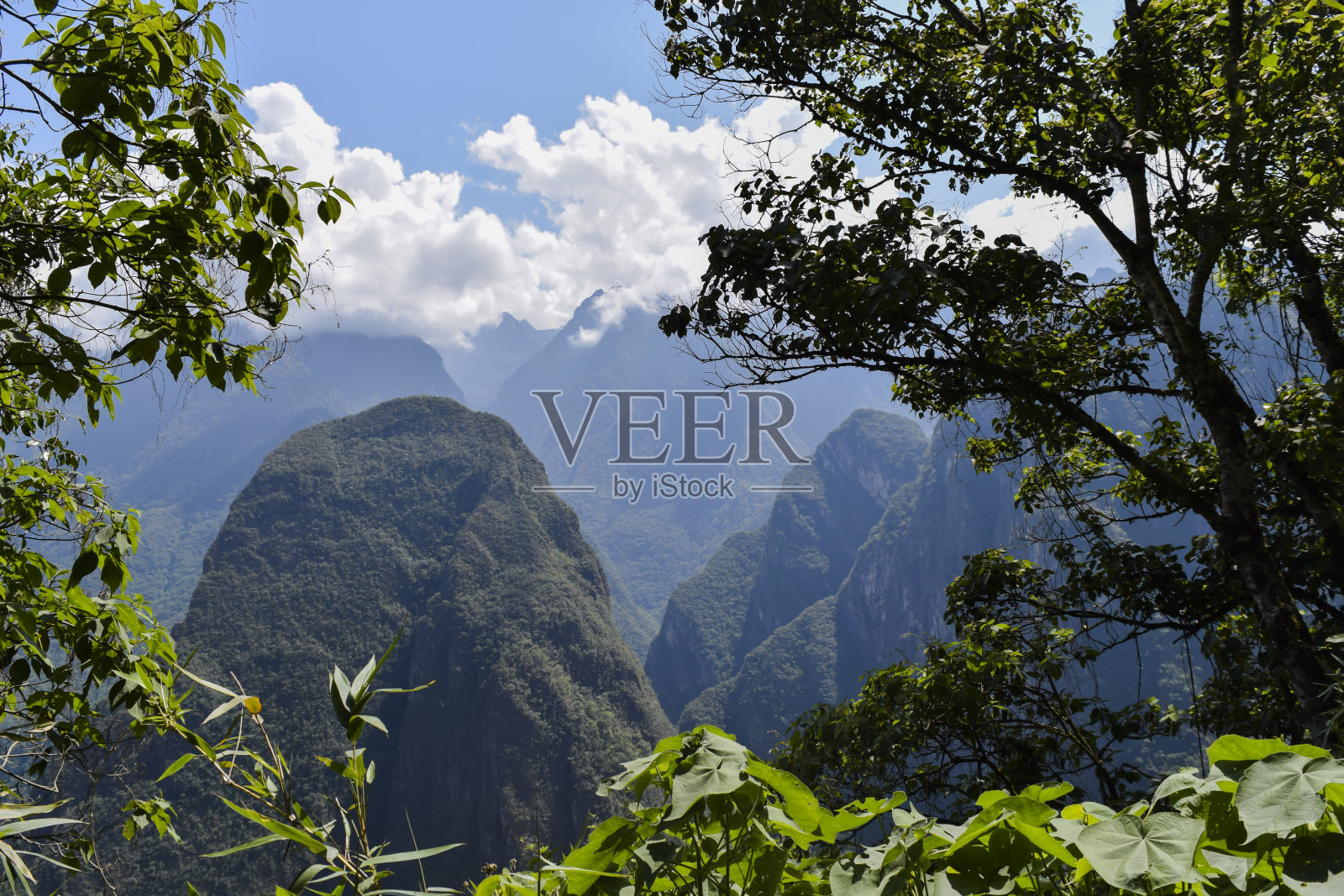 马丘比丘山脉附近的树木之间从小路到达公园入口照片摄影图片