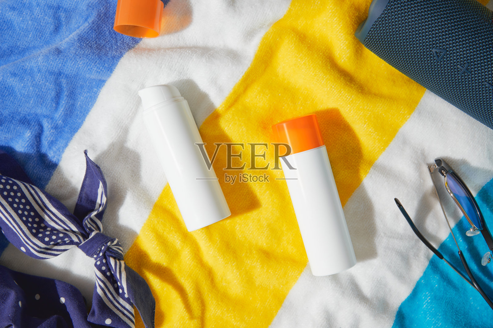 沙滩浴巾上的防晒霜。夏季护理用品照片摄影图片