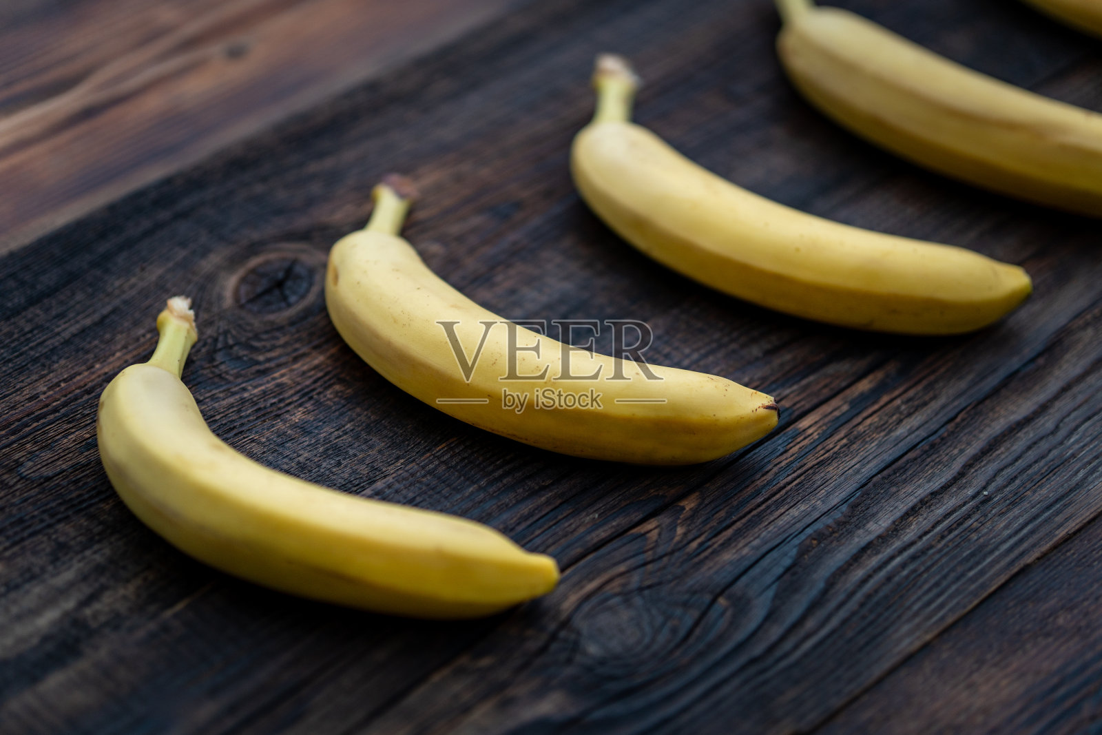香蕉在木制背景上的特写。香蕉在节食中很受欢迎，因为一片香蕉含有更多的纤维。多吃钾、维生素B6和B12等。照片摄影图片