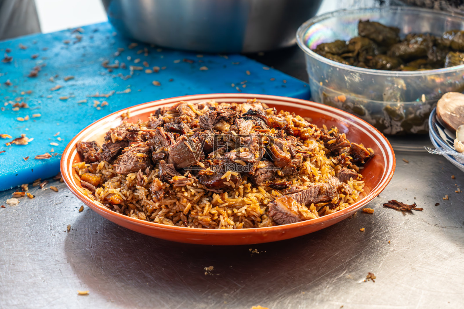 把抓饭放在乌兹别克盘子上。在抓饭中心包装抓饭。塔什干一家咖啡馆的午餐时间。肥米是乌兹别克斯坦的国菜照片摄影图片