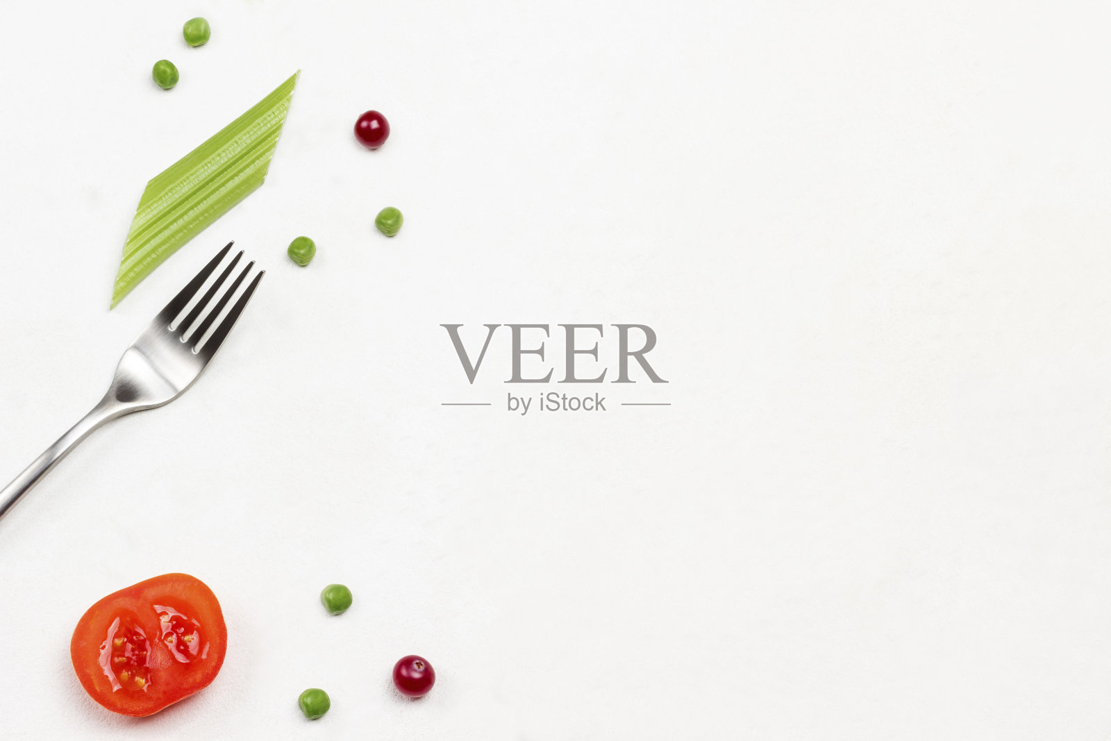 白底餐叉、番茄、蔓越莓和芹菜茎照片摄影图片
