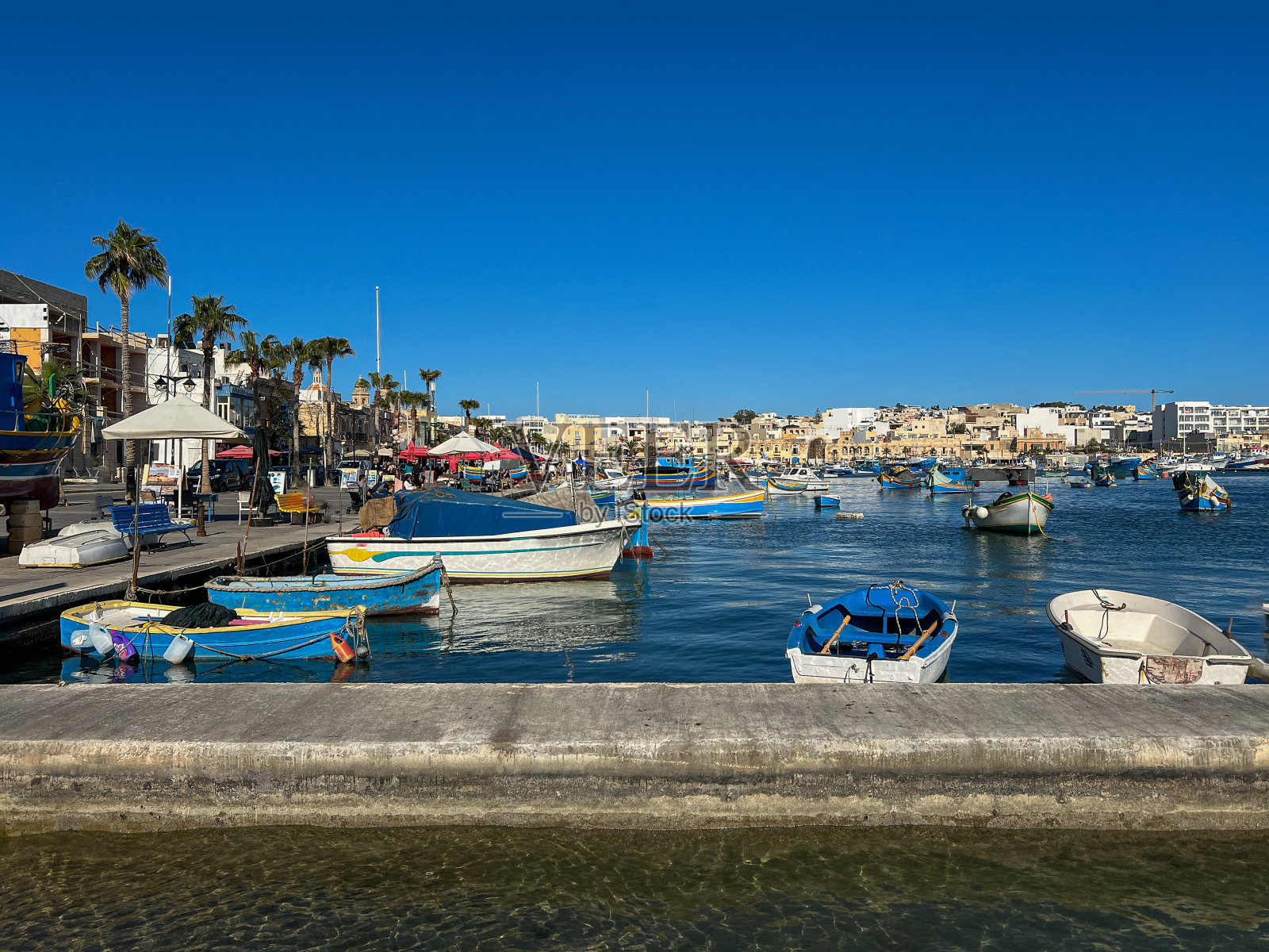 在一个阳光明媚的日子里，渔船停泊在马尔他的马萨斯洛克港照片摄影图片