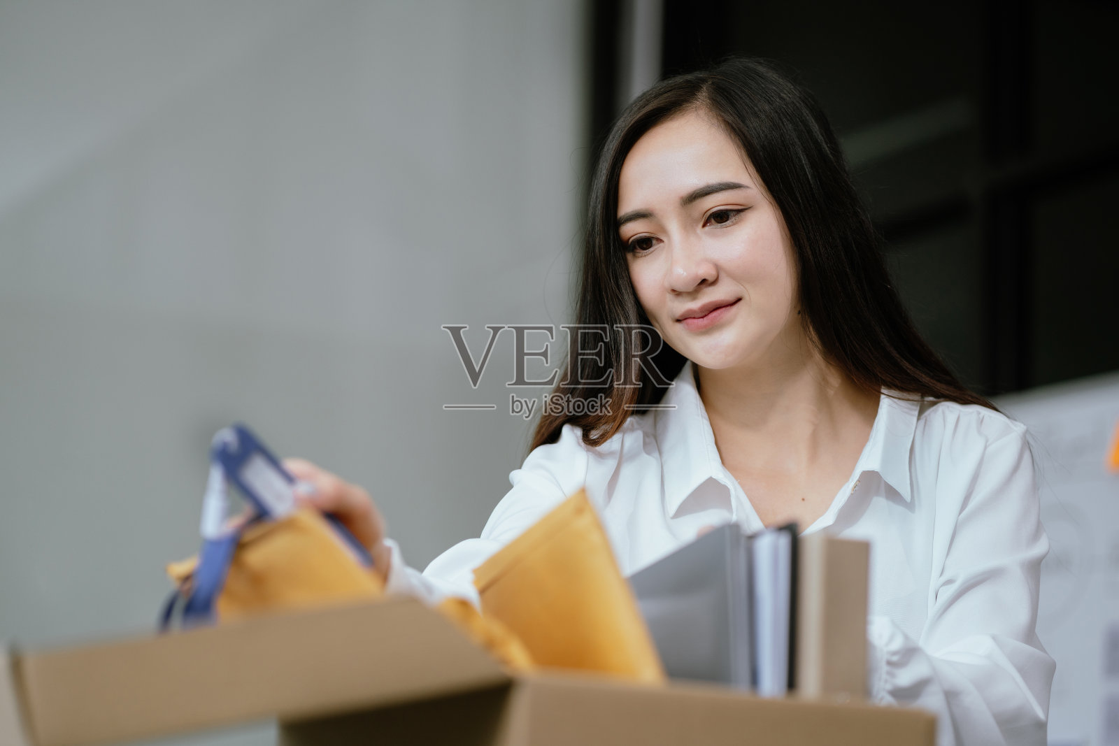 女商人在办公室收拾行李，工作晋升的概念。照片摄影图片