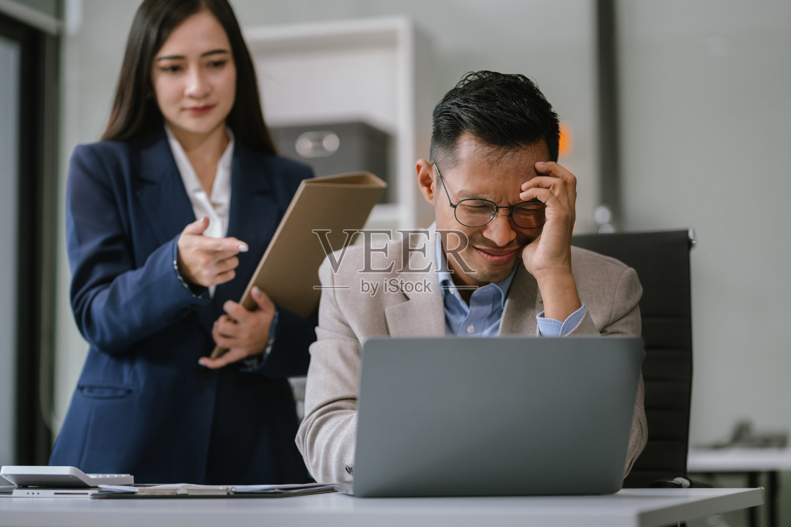 失败的团队合作理念。严肃的商业团队在办公室的桌子上专注于电脑和文书工作。照片摄影图片