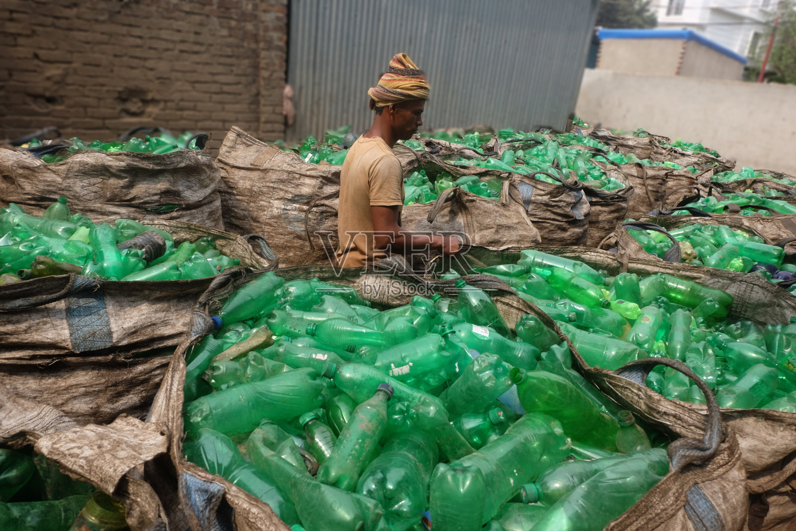 孟加拉吉大港，人们在废弃塑料瓶处理场工作。节约自然，节约污染的理念。照片摄影图片