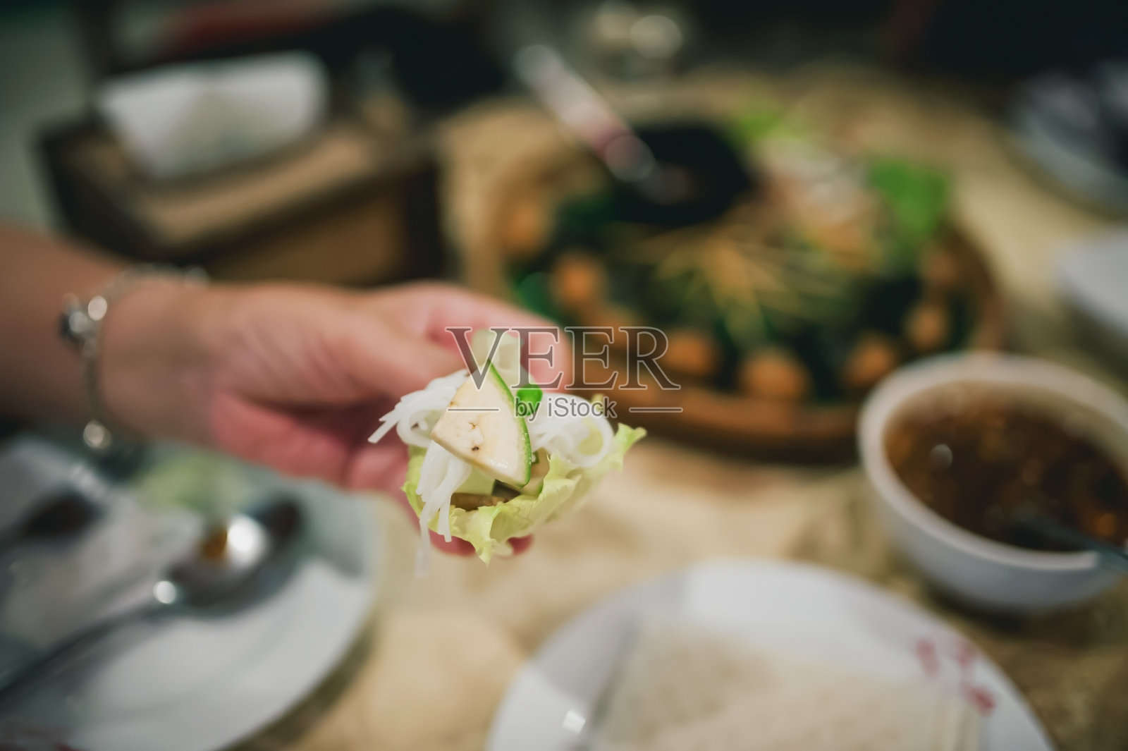 越南菜馕是一种由蔬菜面团、沙拉、生香蕉、辣椒、大蒜和猪肉组成的菜肴，然后淋上甜蘸酱。照片摄影图片