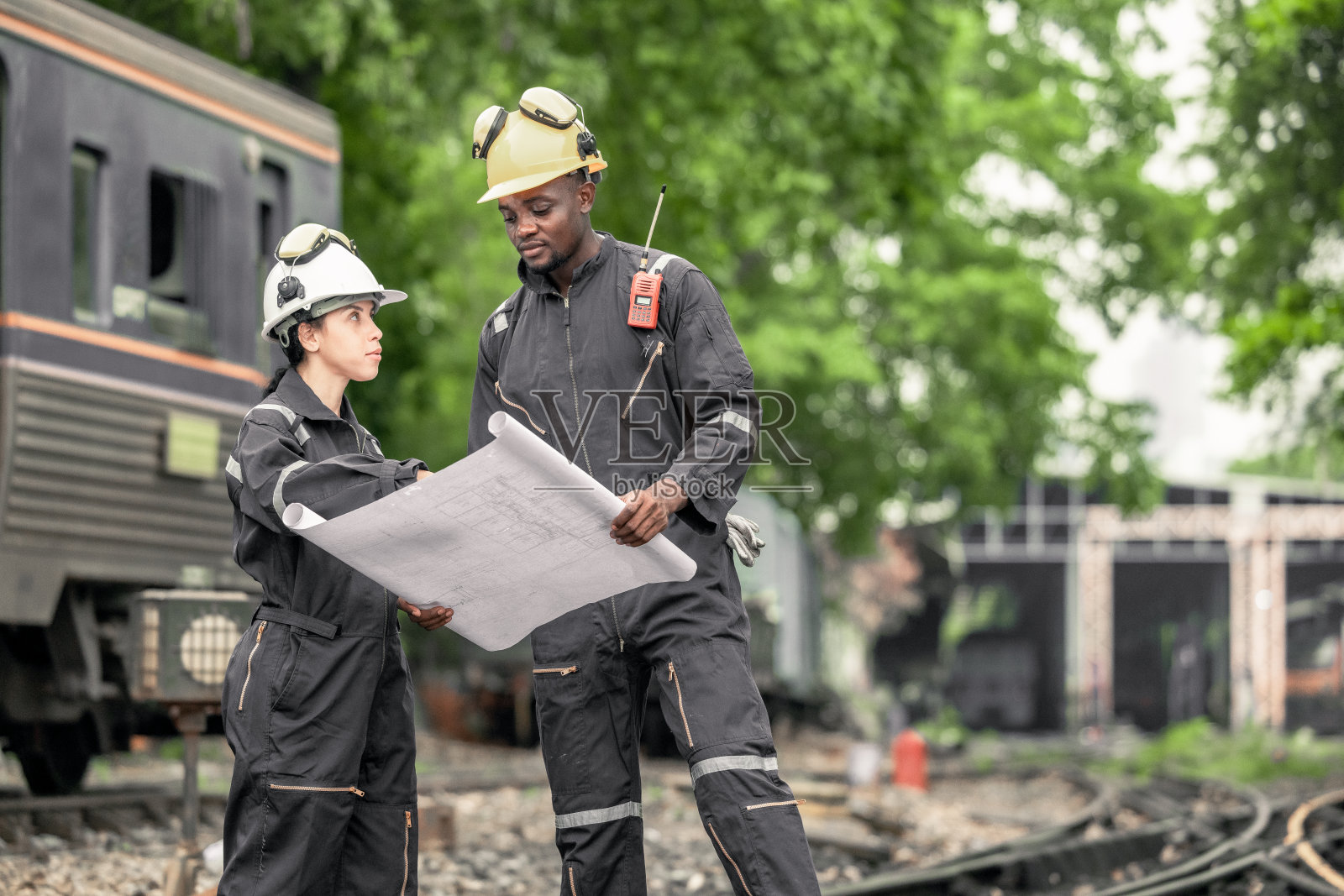 工程师使用蓝图进行铁路维护和故障排除，以确保列车安全运行。照片摄影图片