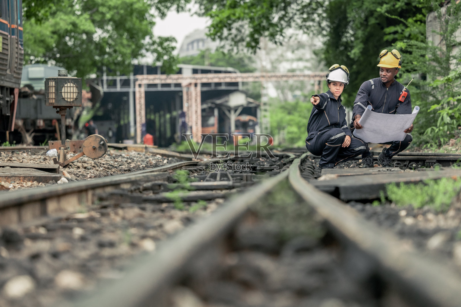 工程师使用蓝图进行铁路维护和故障排除，以确保列车安全运行。照片摄影图片